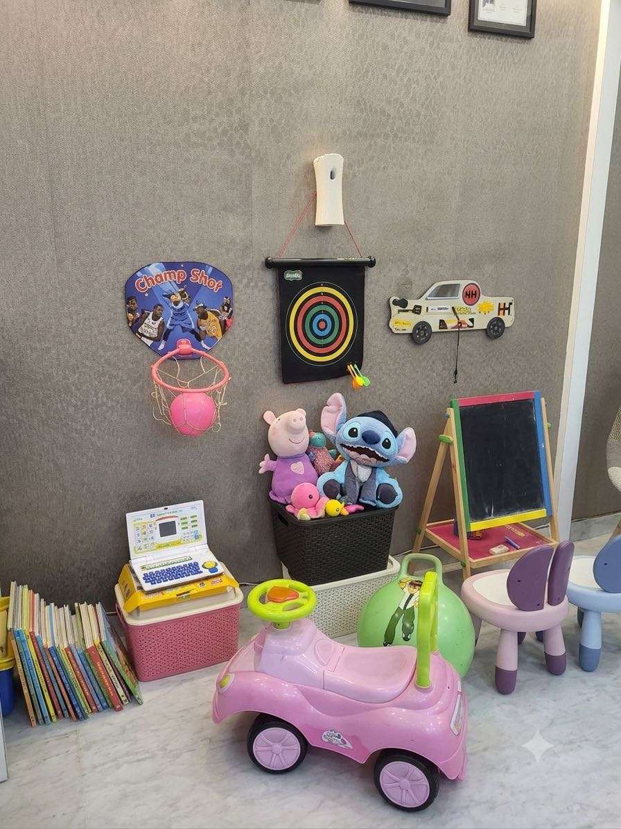 The clinic's play area with toys, books, a chalkboard and a ride-on car