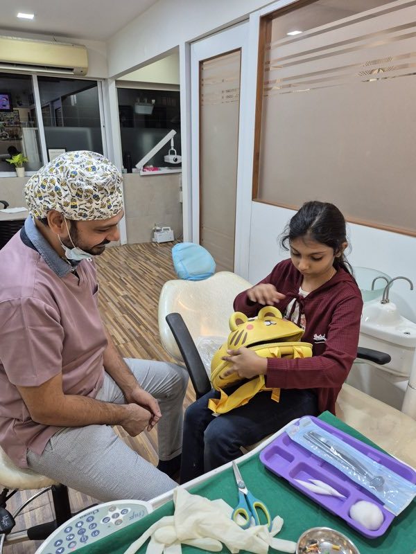 Dr. Arjav Beswal talking through treatment with a young patient in the clinic